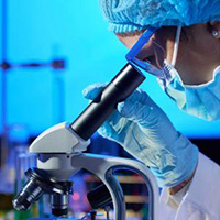 Researcher looking into microscope