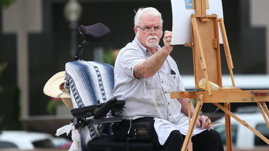 man in wheelchair painting