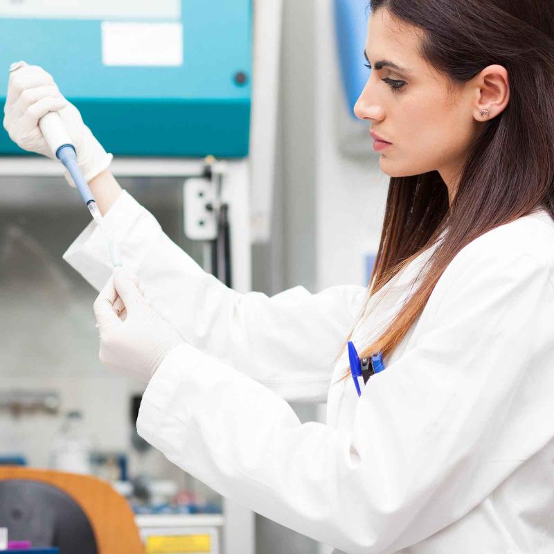 A female researcher taking a sample from a test tube